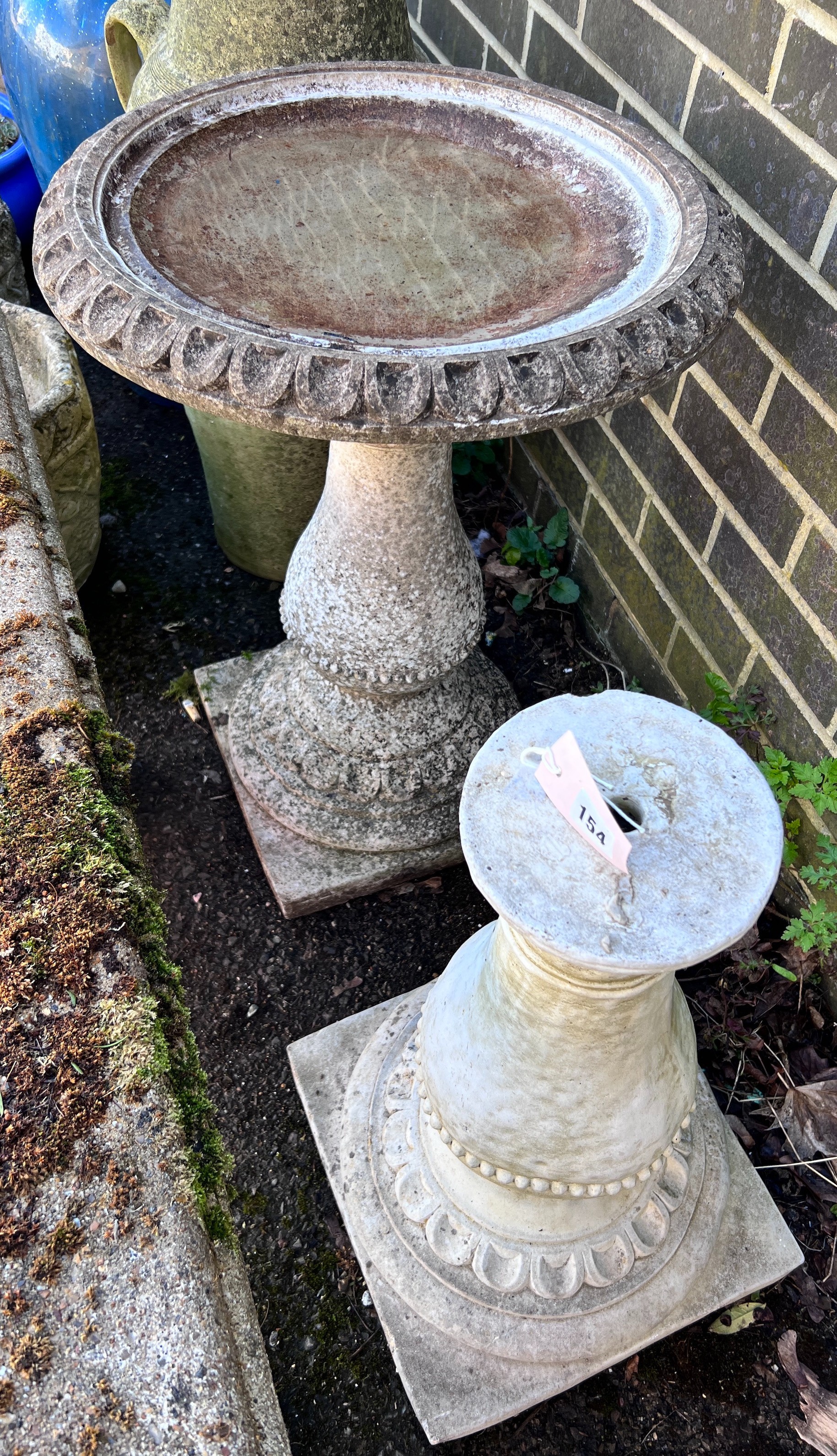 A circular reconstituted stone bird bath, diameter 50cm, height 62cm, together with a faux marble pedestal